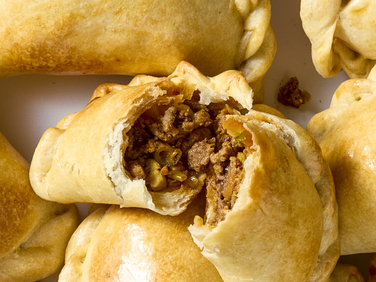 Close-up of a beef empanada torn open showing the filling